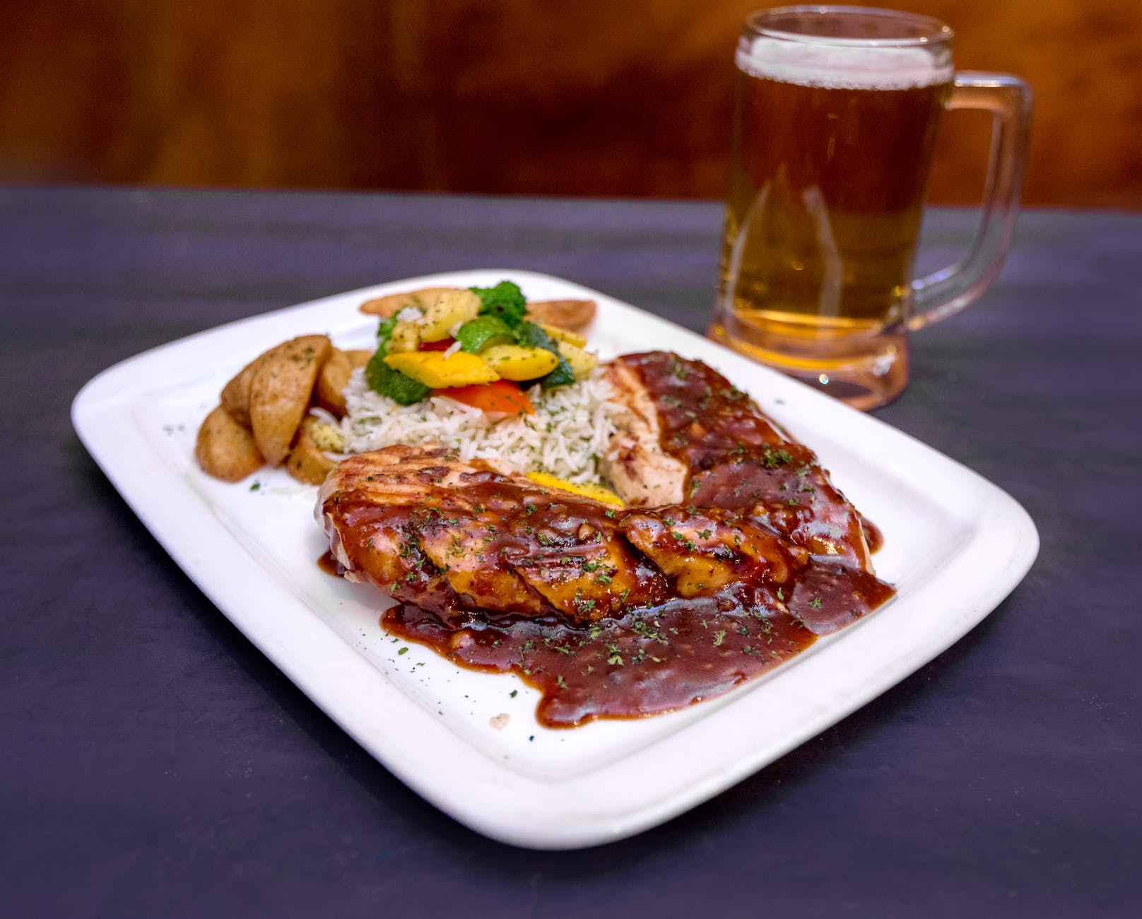 delicious roasted meat steak with potatoes and glass of beer