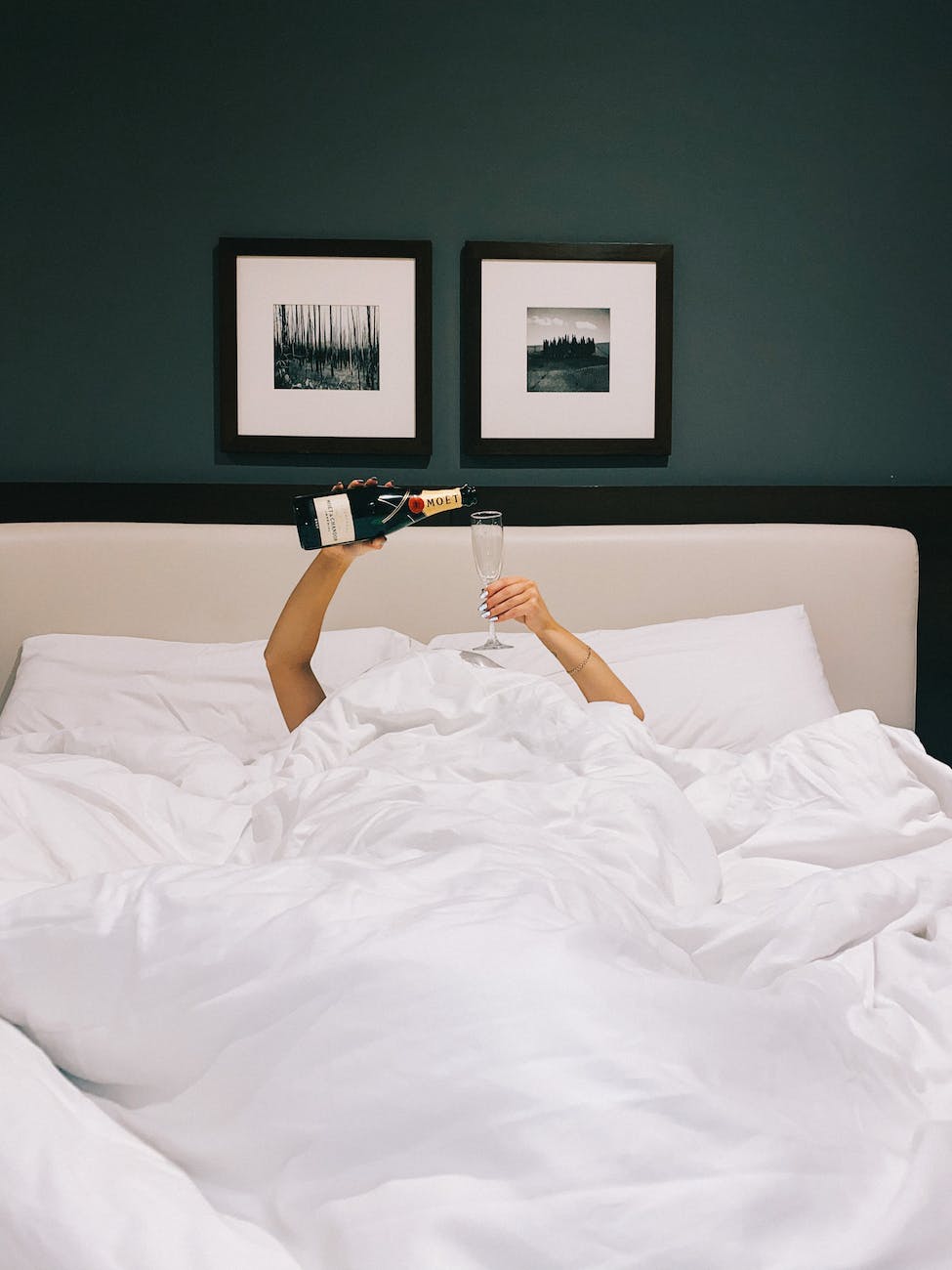 woman pouring champagne in a bed