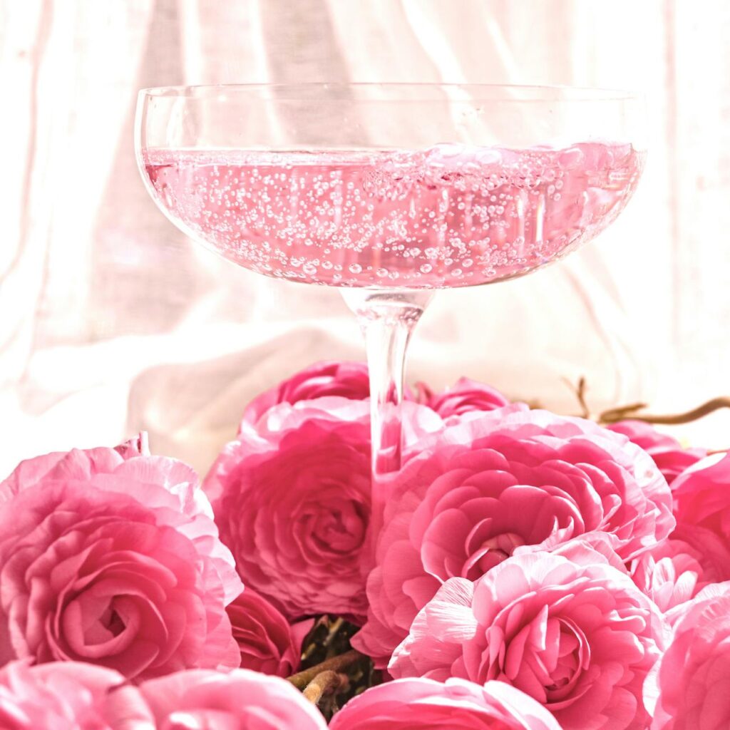 a bunch of pink roses and a glass with drink