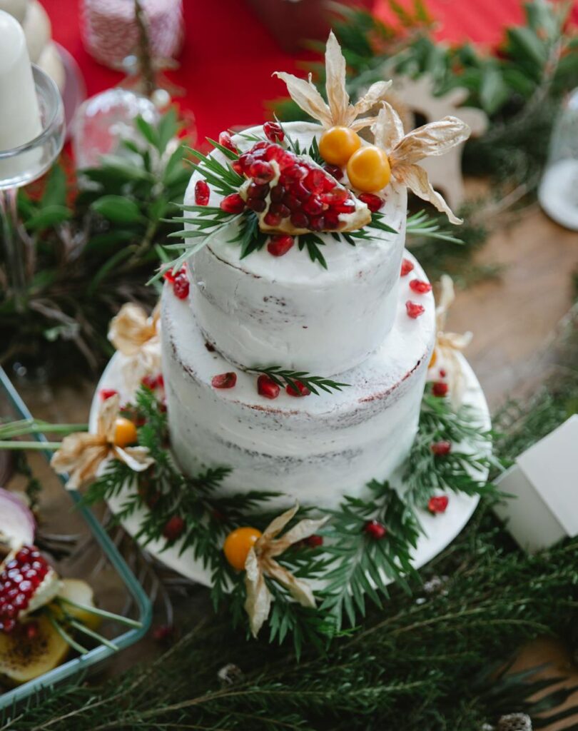 table with delicious cake decorated with berries and leaves