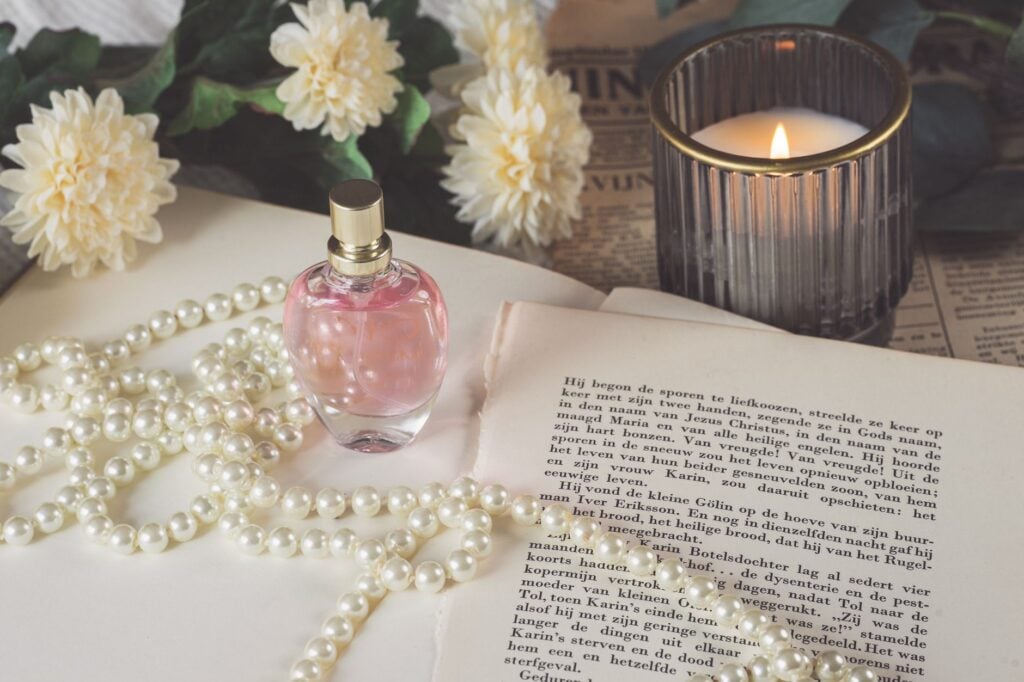 perfume bottle with pearl necklace by candle
